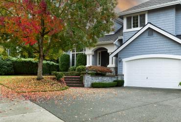 Early autumn residential single family home with colourful tree and sky