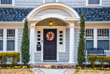 Bluish Grey cedar shake shingled home in early spring with flowers in flower beds