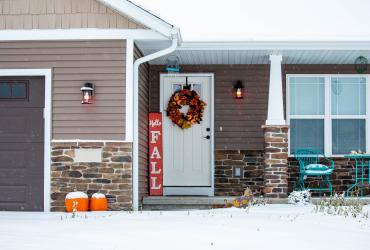 Residential house decorated for autumn with snow on the ground