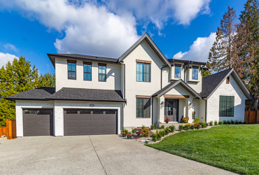 luxury two garage big white home with luscious green grass on a blue sky day in the suburbs